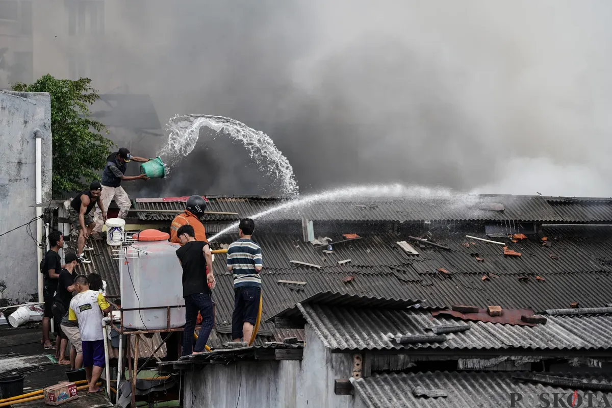 Petugas pemadam kebakaran memadamkan api yang membakar pemukiman padat penduduk di kawasan Grogol Utara, Kebayoran Lama, Jakarta Selatan, Minggu, 20 Juli 2025. (Sumber: Poskota/Bilal Nugraha Ginanjar)