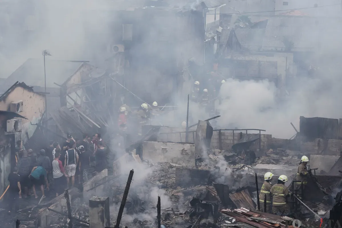 Petugas pemadam kebakaran memadamkan api yang membakar pemukiman padat penduduk di kawasan Grogol Utara, Kebayoran Lama, Jakarta Selatan, Minggu, 20 Juli 2025. (Sumber: Poskota/Bilal Nugraha Ginanjar)