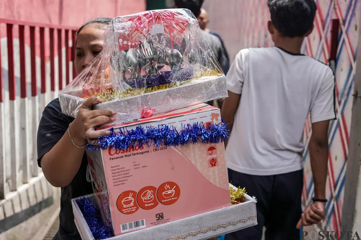Warga menyelematkan barang dari kebakaran yang menghanguskan pemukiman padat penduduk di kawasan Grogol Utara, Kebayoran Lama, Jakarta Selatan, Minggu, 20 Juli 2025. (Sumber: Poskota/Bilal Nugraha Ginanjar)