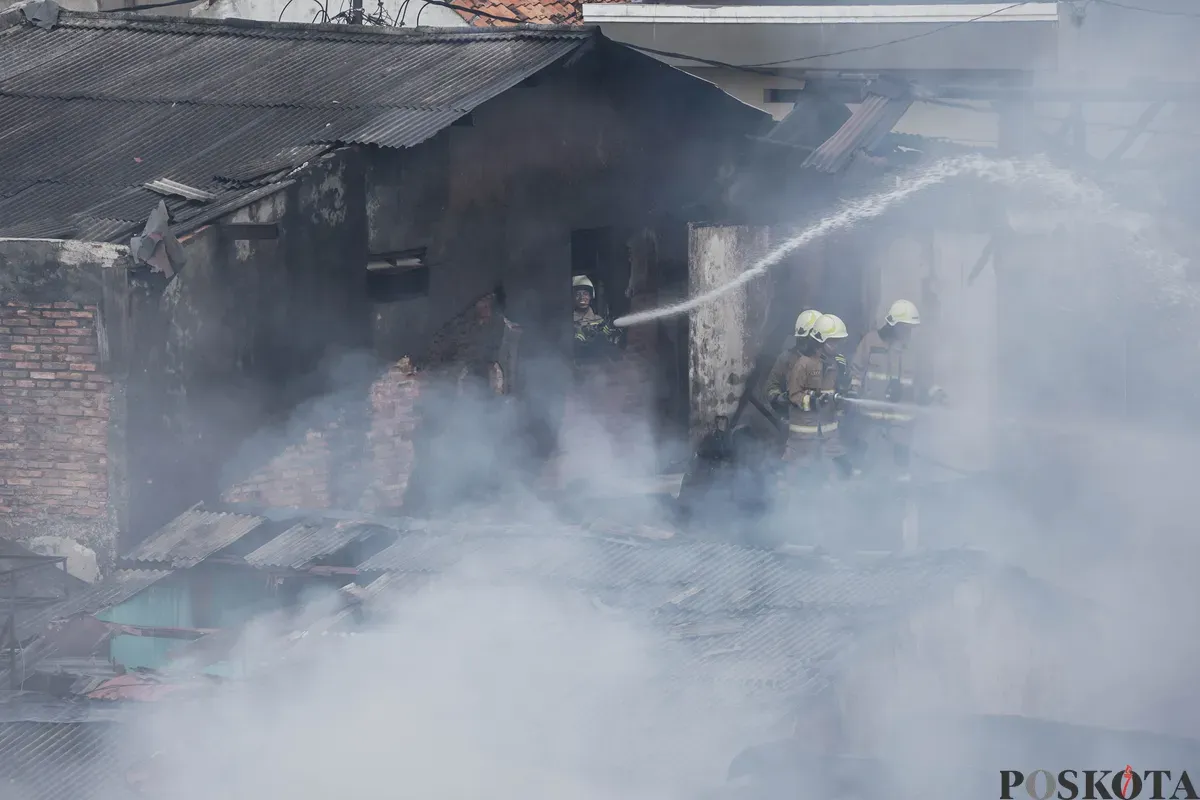 Petugas pemadam kebakaran memadamkan api yang membakar pemukiman padat penduduk di kawasan Grogol Utara, Kebayoran Lama, Jakarta Selatan, Minggu, 20 Juli 2025. (Sumber: Poskota/Bilal Nugraha Ginanjar)