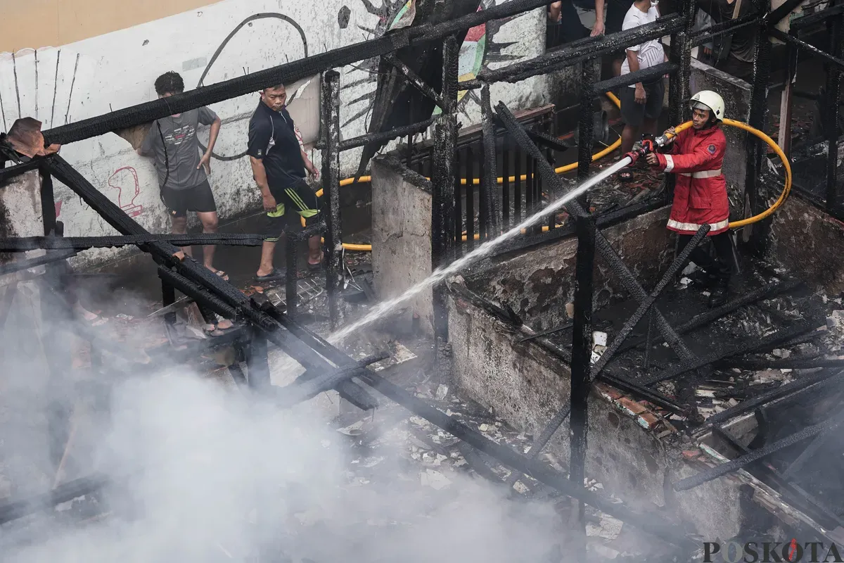 Petugas pemadam kebakaran memadamkan api yang membakar pemukiman padat penduduk di kawasan Grogol Utara, Kebayoran Lama, Jakarta Selatan, Minggu, 20 Juli 2025. (Sumber: Poskota/Bilal Nugraha Ginanjar)