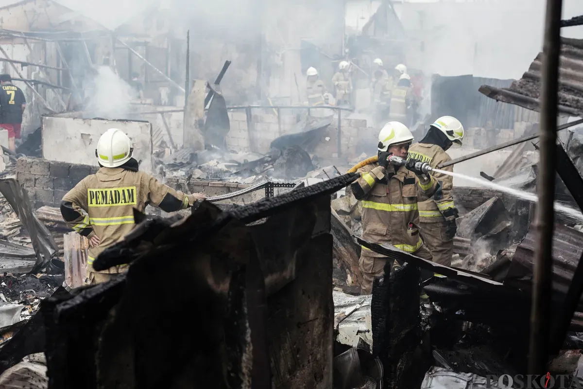 Petugas pemadam kebakaran memadamkan api yang membakar pemukiman padat penduduk di kawasan Grogol Utara, Kebayoran Lama, Jakarta Selatan, Minggu, 20 Juli 2025. (Sumber: Poskota/Bilal Nugraha Ginanjar)