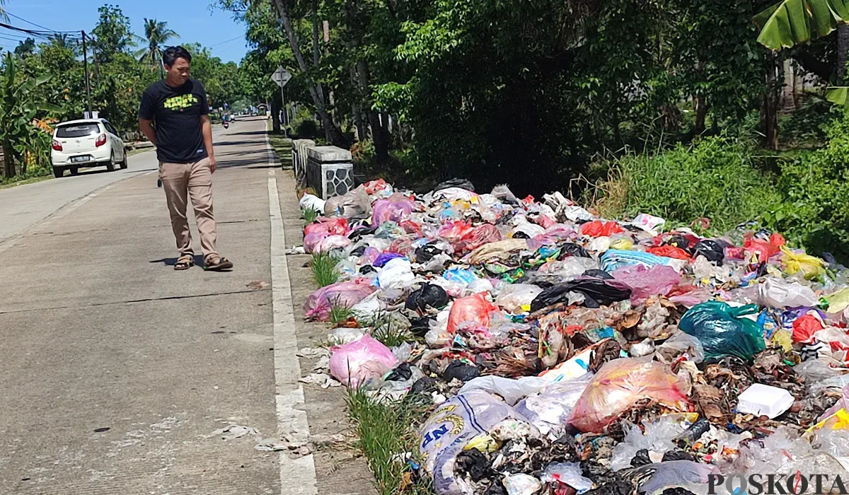 Warga mengamati tumpukan sampah di Jalan Raya Sobang-Ciseket, Desa Mekarsari, Kecamatan Panimbang, Pandeglang. (Sumber: POSKOTA | Foto: Samsul Fatoni)