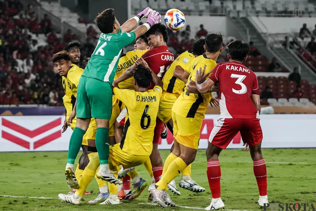 Pemain Timnas U-23 Indonesia Hokky Caraka berebut bola di udara dengan para pemain Timnas U-23 Malaysia dalam pertandingan penyisihan Grup A Piala AFF U-23 2025 di Stadion Utama Gelora Bung Karno (SUGBK), Senayan, Jakarta, 18 Juli 2025. (Sumber: Poskota/Bilal Nugraha Ginanjar)