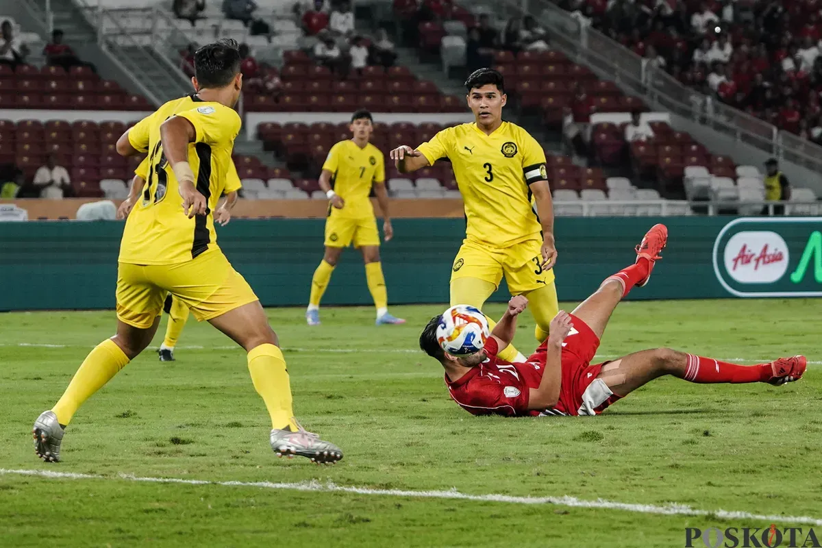 Pemain Timnas U-23 Indonesia Jens Raven terjatuh usai berebut bola dengan para pemain Timnas U-23 Malaysia dalam pertandingan penyisihan Grup A Piala AFF U-23 2025 di Stadion Utama Gelora Bung Karno (SUGBK), Senayan, Jakarta, 18 Juli 2025. (Sumber: Poskota/Bilal Nugraha Ginanjar)