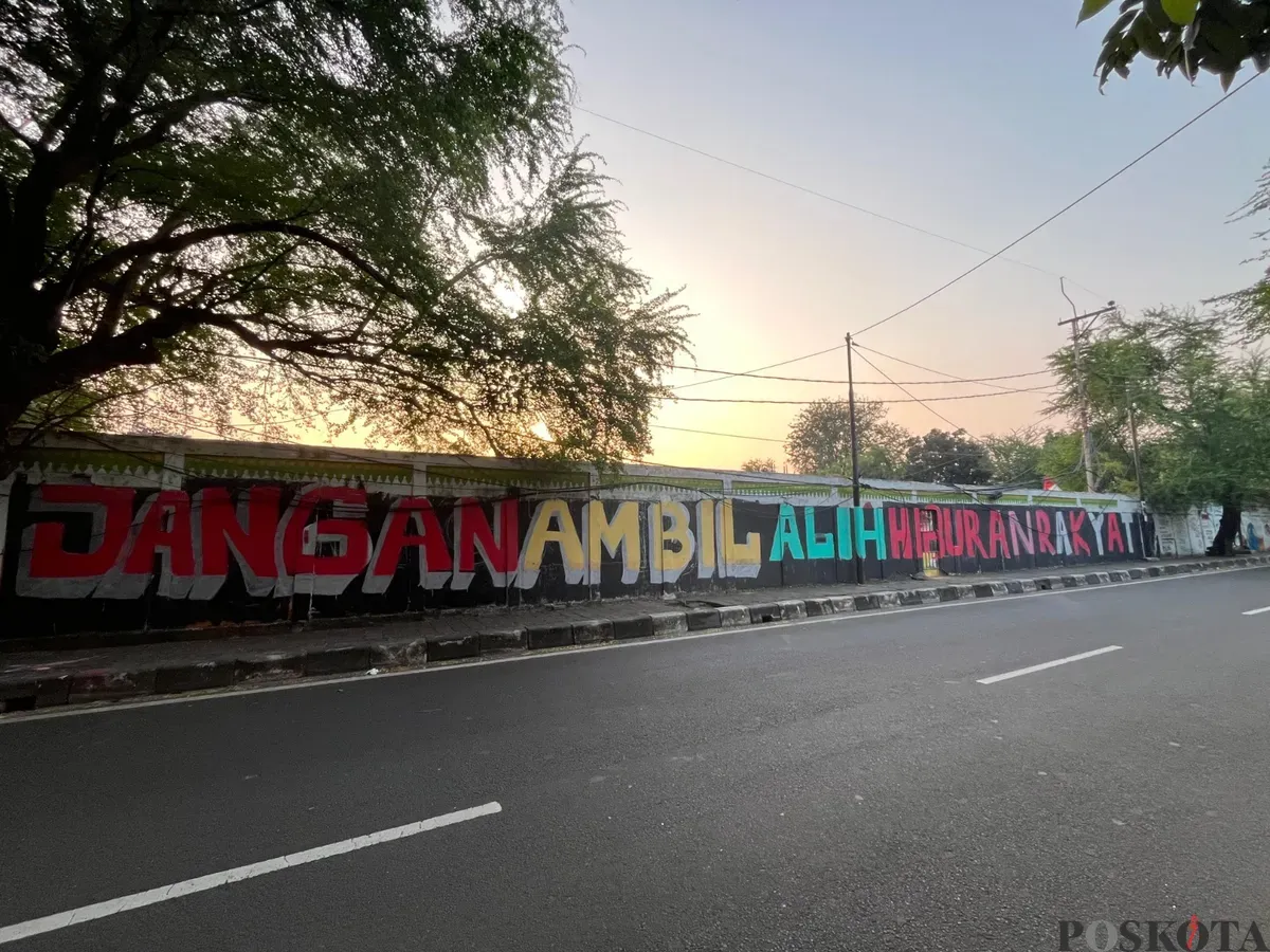 Coretan pada dinding menunjukan penolakan warga Kedoya Selatan terkait wacana alih fungsi lapangan sepak bola menjadi sarana olahraga Padel. (Sumber: Poskota/Pandi Ramedhan)