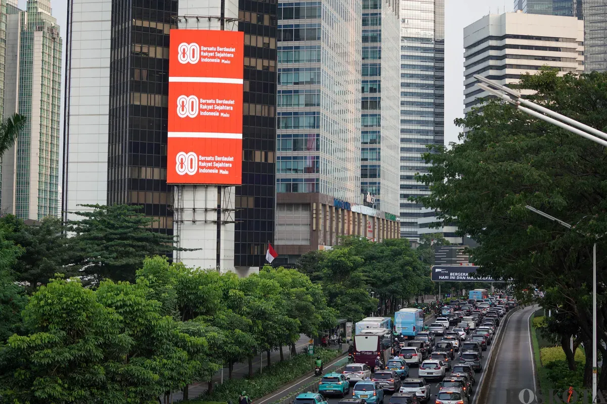 Sejumlah kendaraan melintas di dekat Videotron yang menampilkan logo HUT RI ke-80 di kawasan Jalan Sudirman, Jakarta, Kamis, 24 Juli 2025. (Sumber: Poskota/Bilal Nugraha Ginanjar)