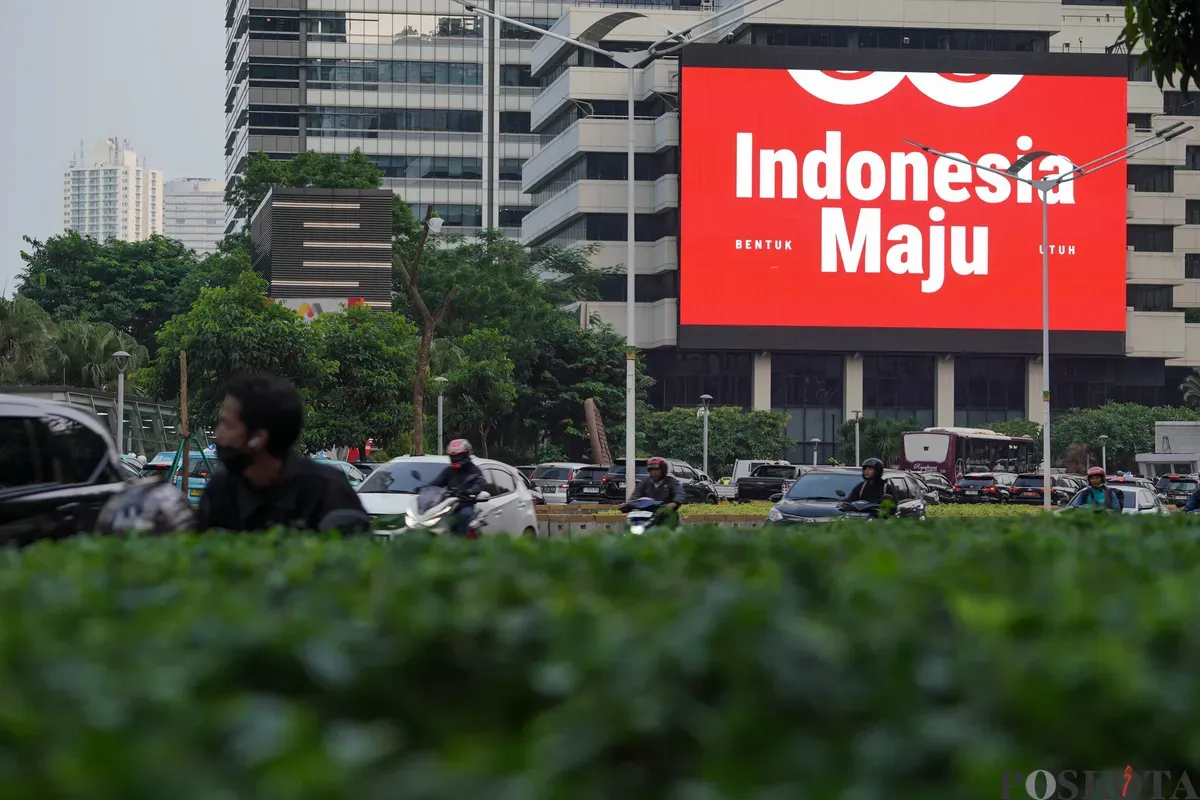 Sejumlah kendaraan melintas di dekat Videotron yang menampilkan logo HUT RI ke-80 di kawasan Jalan Sudirman, Jakarta, Kamis, 24 Juli 2025. (Sumber: Poskota/Bilal Nugraha Ginanjar)