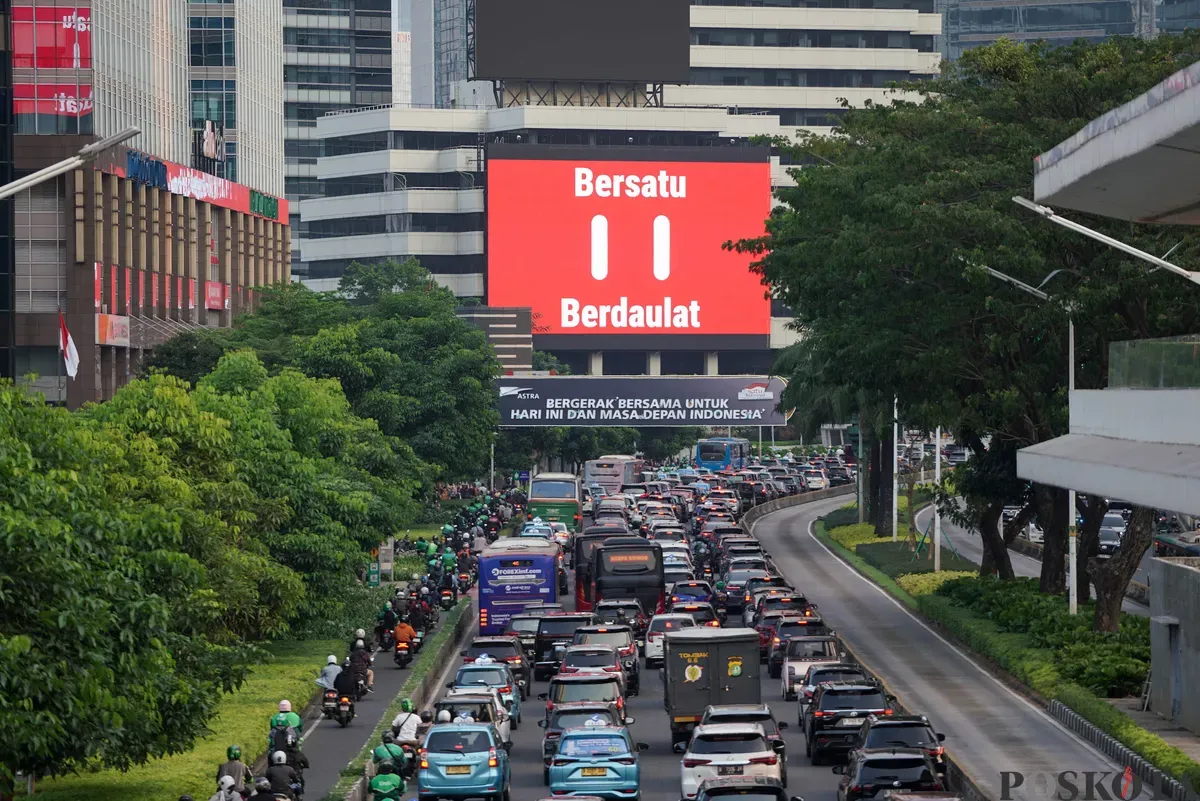 Sejumlah kendaraan melintas di dekat Videotron yang menampilkan logo HUT RI ke-80 di kawasan Jalan Sudirman, Jakarta, Kamis, 24 Juli 2025. (Sumber: Poskota/Bilal Nugraha Ginanjar)