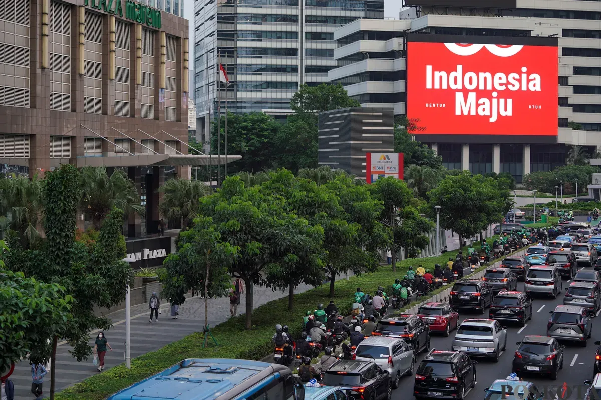 Sejumlah kendaraan melintas di dekat Videotron yang menampilkan logo HUT RI ke-80 di kawasan Jalan Sudirman, Jakarta, Kamis, 24 Juli 2025. (Sumber: Poskota/Bilal Nugraha Ginanjar)