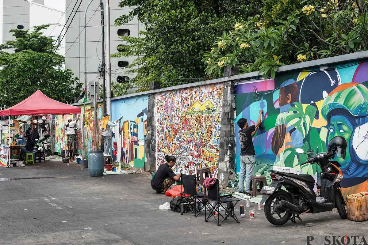 Pelukis mural atau muralis menyelesaikan karyanya di kawasan Kalipasir, Cikini, Jakarta, Kamis, 24 Juli 2025. (Sumber: Poskota/Bilal Nugraha Ginanjar)