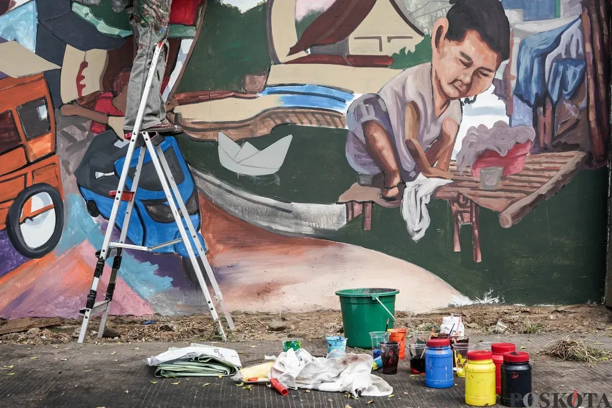 Pelukis mural atau muralis menyelesaikan karyanya di kawasan Kalipasir, Cikini, Jakarta, Kamis, 24 Juli 2025. (Sumber: Poskota/Bilal Nugraha Ginanjar)