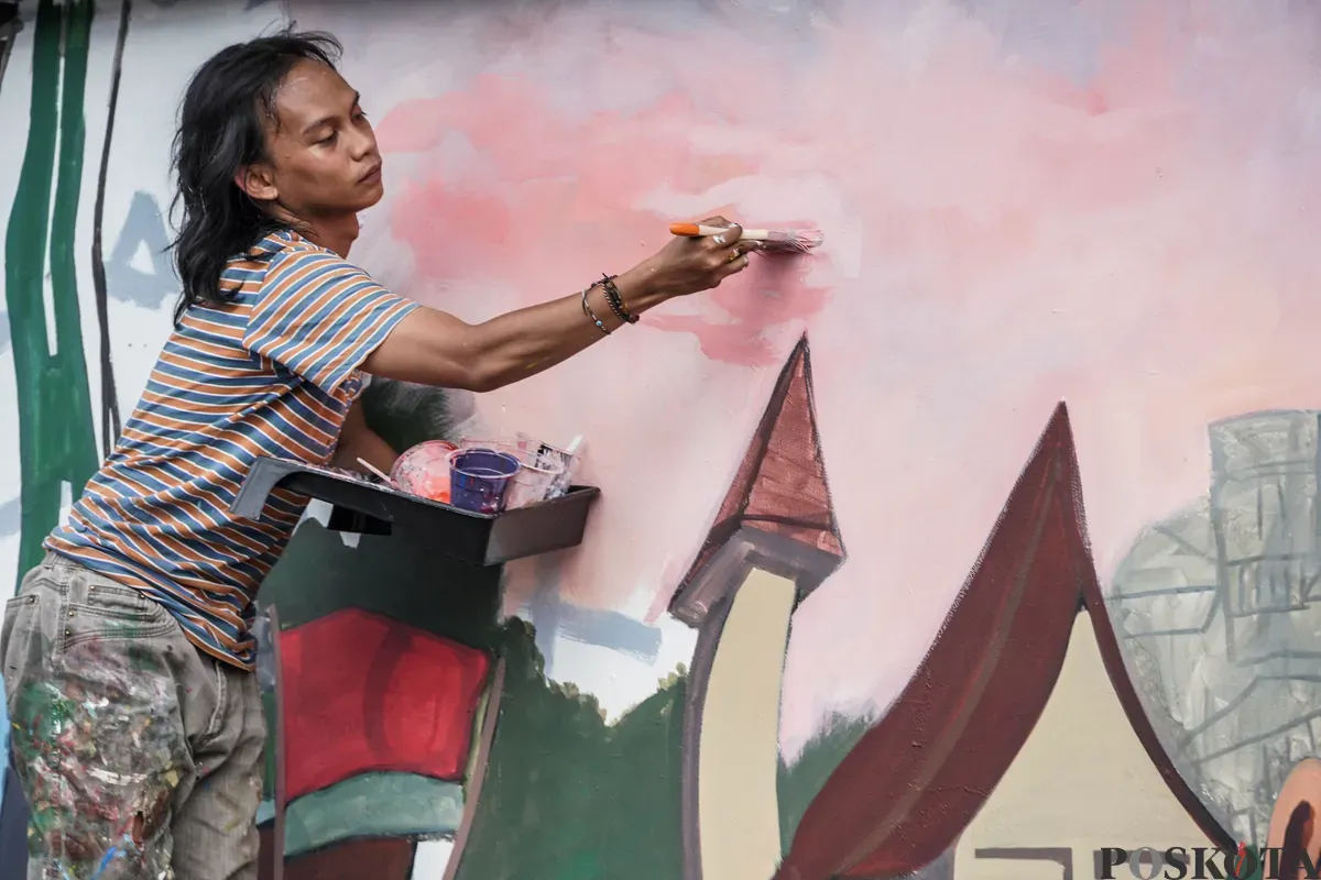 Pelukis mural atau muralis menyelesaikan karyanya di kawasan Kalipasir, Cikini, Jakarta, Kamis, 24 Juli 2025. (Sumber: Poskota/Bilal Nugraha Ginanjar)