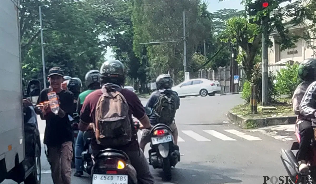 Aktivitas seorang pengamen di lampu merah Jalan Manunggal, Kota Bogor. (Sumber: POSKOTA | Foto: Sekar Putri Andini)
