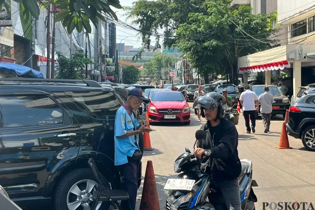 Salah seorang petugas parkir saat membantu pengendara mengeluarkan motornya di Jalan Palatehan I, Kebayoran Baru, Jakarta Selatan, Kamis, 31 Juli 2025. (Sumber: Poskota/Muhammad Tegar Jihad)