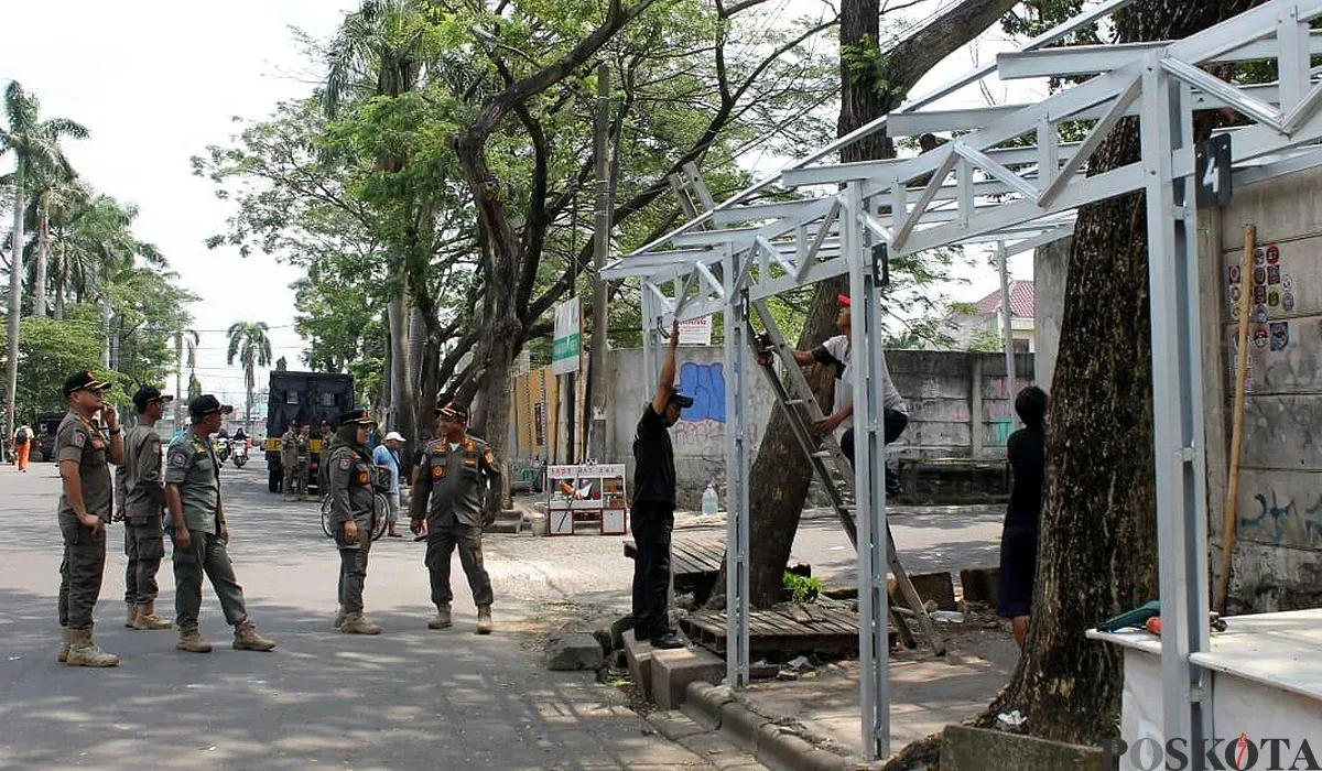 Petugas Satpol PP membongkar puluhan lapak yang di Jalan Nusa Raya, Kalideres, Jakarta Barat, pada Kamis, 31 Juli 2025. (Sumber: POSKOTA | Foto: Pandi Ramedhan)