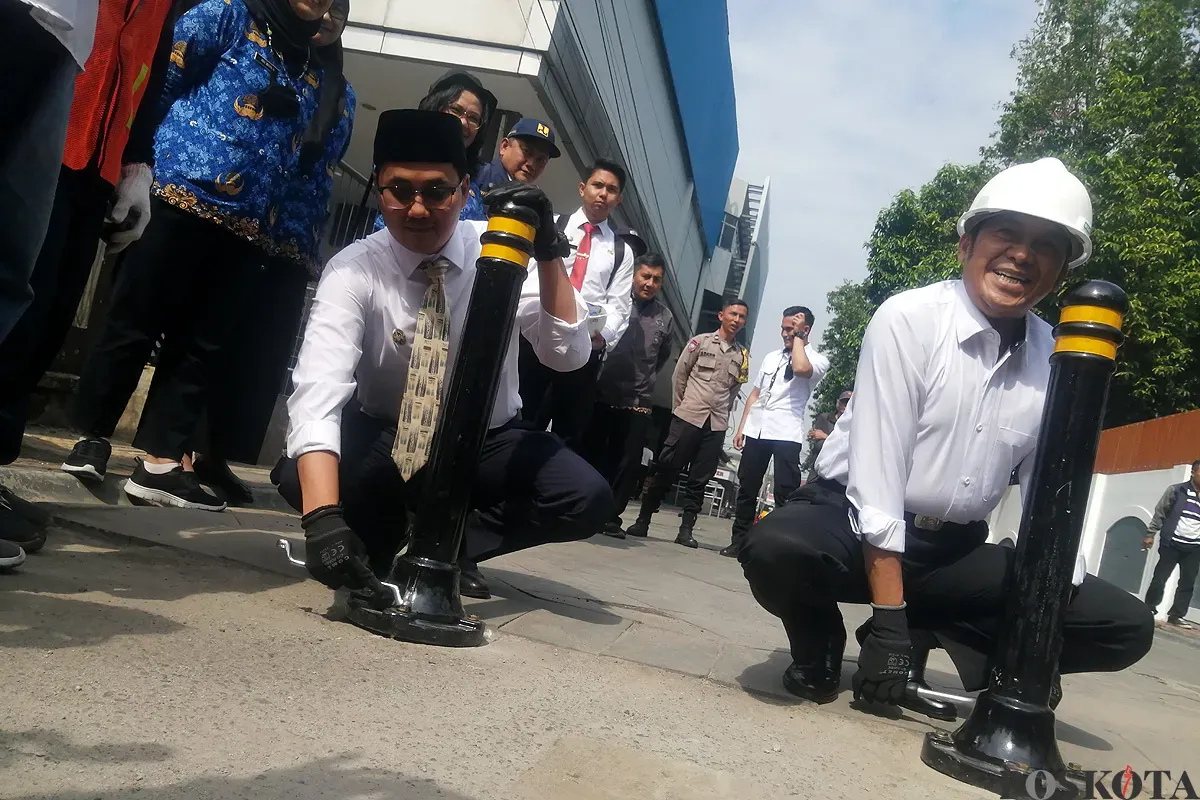 Wali Kota Cimahi, Ngatiyana (kanan), dan Wakil Wali Kota, Adithiya Yudhistira (kiri), memasang tiang pembatas di kawasan Alun-alun timur, Jalan Ria, Senin 2 Juni 2025. (Sumber: POSKOTA | Foto: Gatot Poedji Utomo)