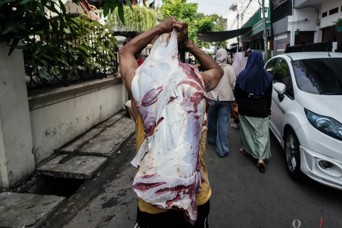 Warga membawa potongan daging sapi yang telah disembelih saat Hari Raya Idul Adha di kawasan Jalan Kebon Kacang, Tanah Abang, Jakarta, Jum'at, 6 Juni 2025. (Sumber: Poskota/Bilal Nugraha Ginanjar)