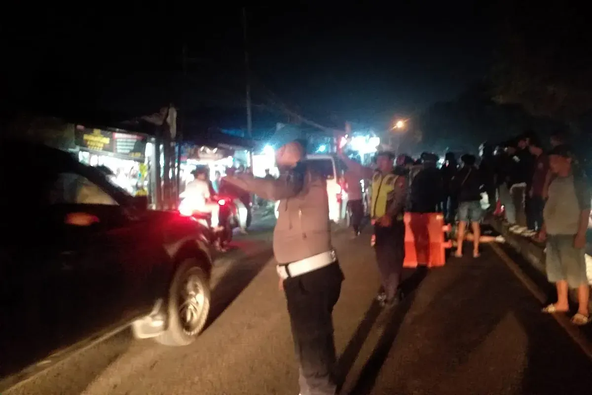 Petugas dari Polsek Cimanggis mengatur arus lalu lintas di lokasi kecelakaan yang menewaskan dua orang di Jalan Raya Bogor, Cimanggis, Depok pada Sabtu malam, 7 Juni 2025. (Sumber: Istimewa)