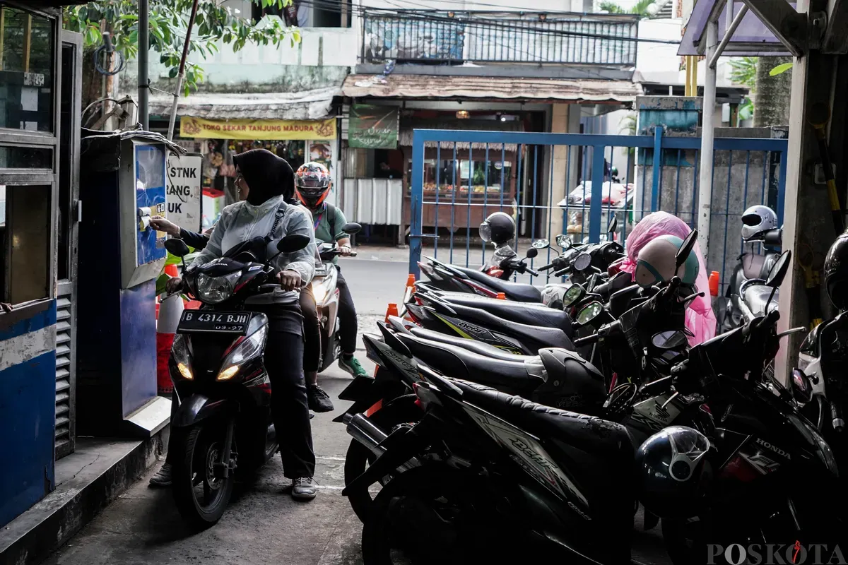 Pengendara mengambil karcis parkir di Park and Ride Vertical Ragunan, Jakarta Selatan, Rabu, 11 Juni 2025. (Sumber: Poskota/Bilal Nugraha Ginanjar)