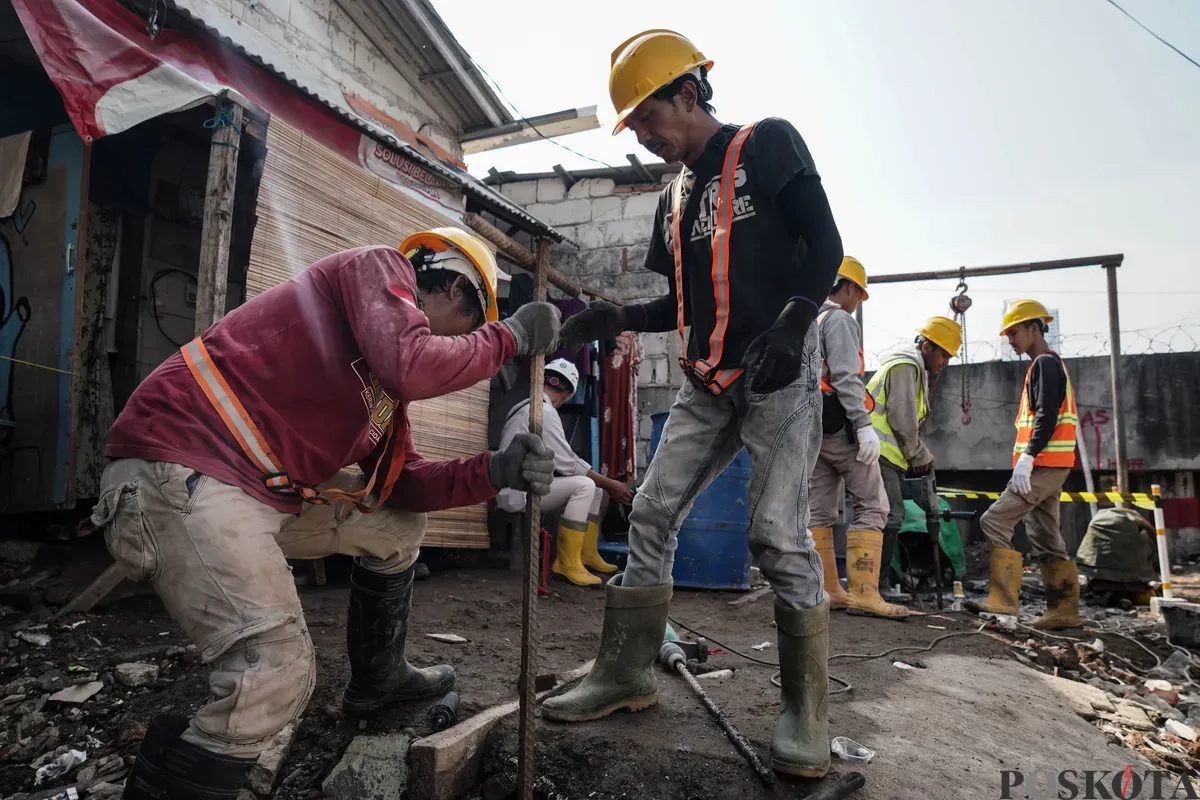 Pekerja menyelesaikan pembangunan tanggul mitigasi banji rob di Jalan Dermaga Ujung, Muara Angke, Jakarta, Kamis, 12 Juni 2025. (Sumber: Poskota/Bilal Nugraha Ginanjar)