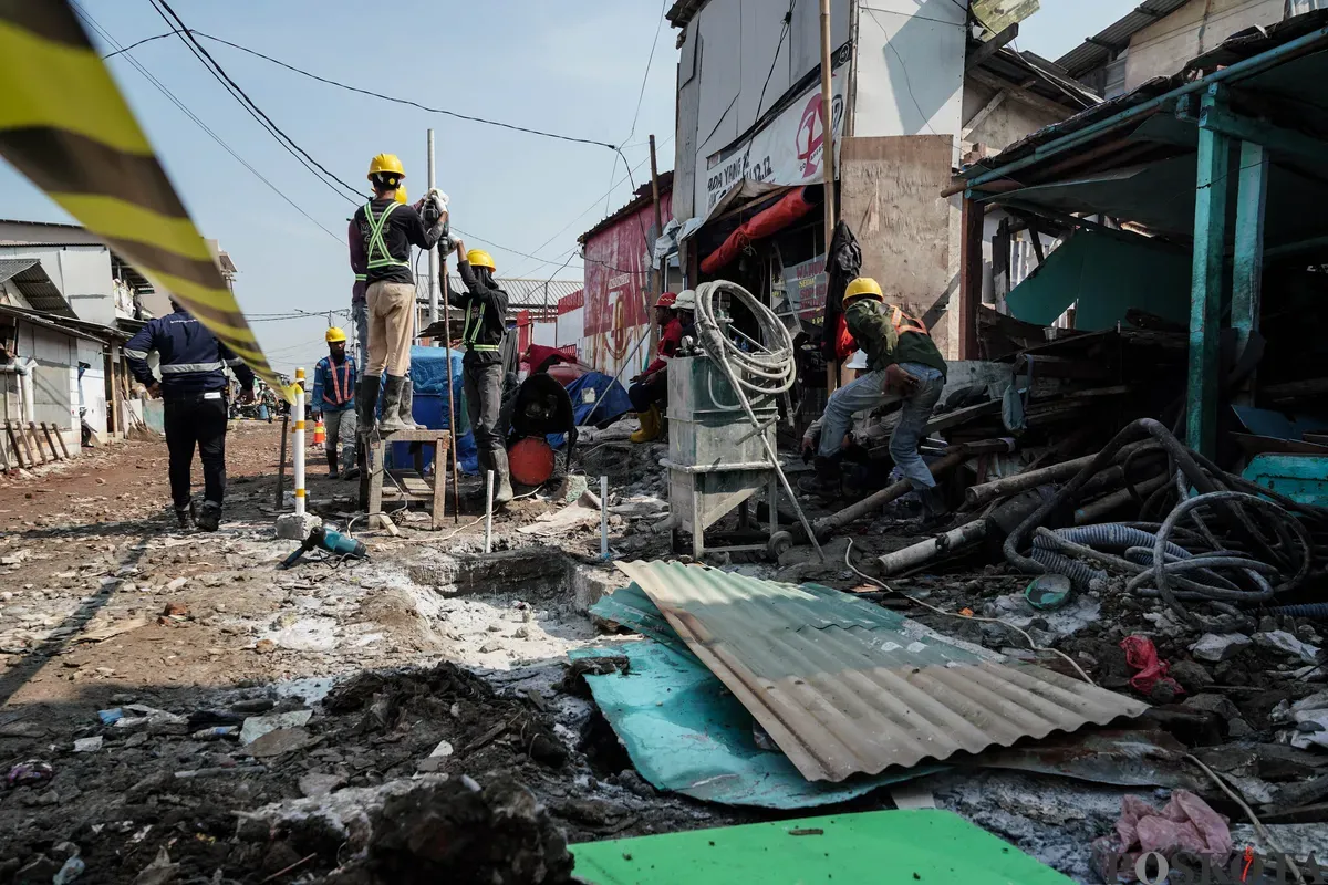 Pekerja menyelesaikan pembangunan tanggul mitigasi banji rob di Jalan Dermaga Ujung, Muara Angke, Jakarta, Kamis, 12 Juni 2025. (Sumber: Poskota/Bilal Nugraha Ginanjar)