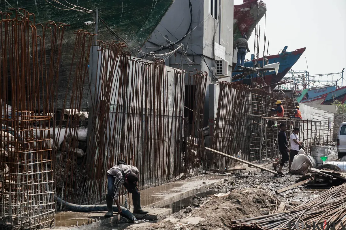 Pekerja menyelesaikan pembangunan tanggul mitigasi di area Docking Kapal Baywalk, Pluit, Jakarta, Kamis, 12 Juni 2025. (Sumber: Poskota/Bilal Nugraha Ginanjar)
