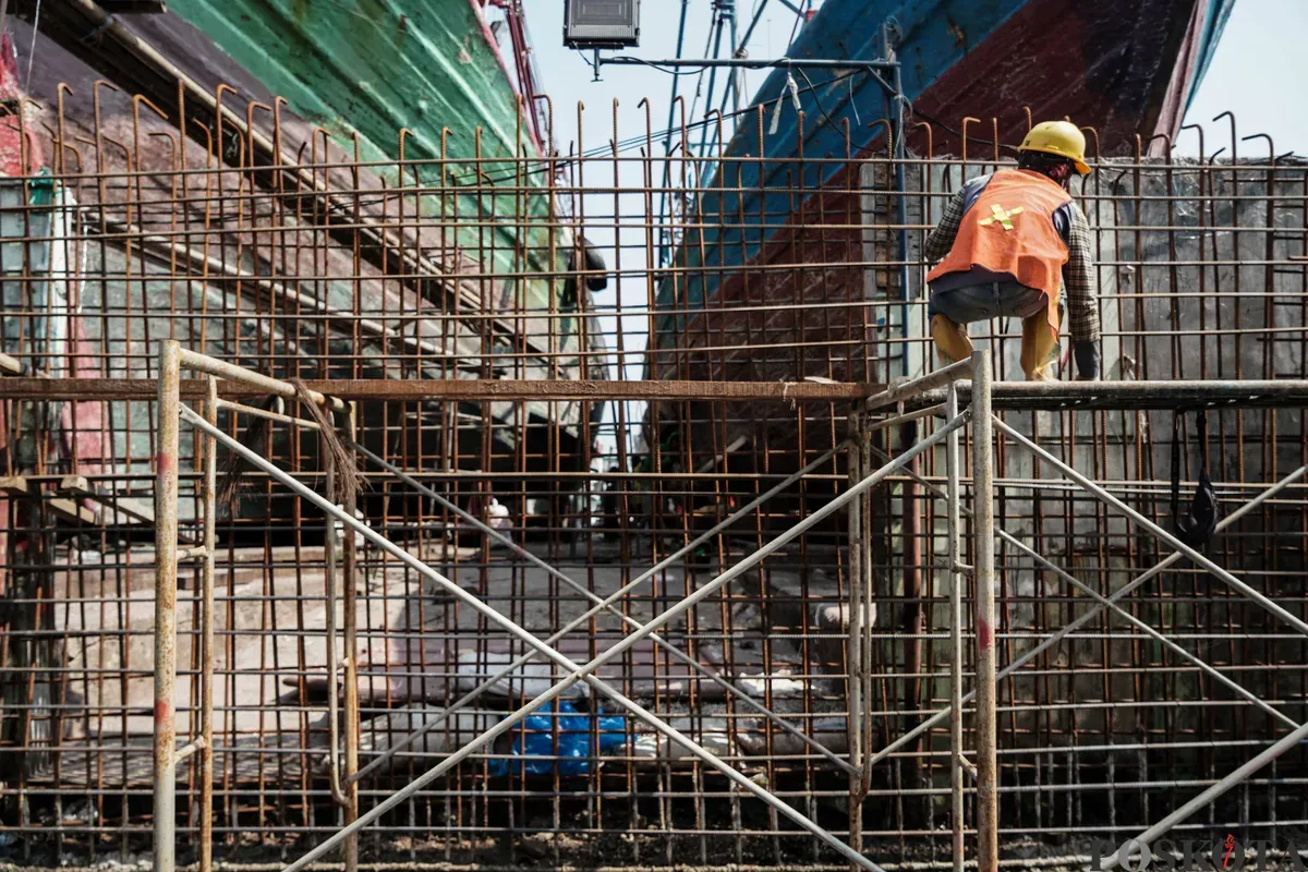 Pekerja menyelesaikan pembangunan tanggul mitigasi di area Docking Kapal Baywalk, Pluit, Jakarta, Kamis, 12 Juni 2025. (Sumber: Poskota/Bilal Nugraha Ginanjar)