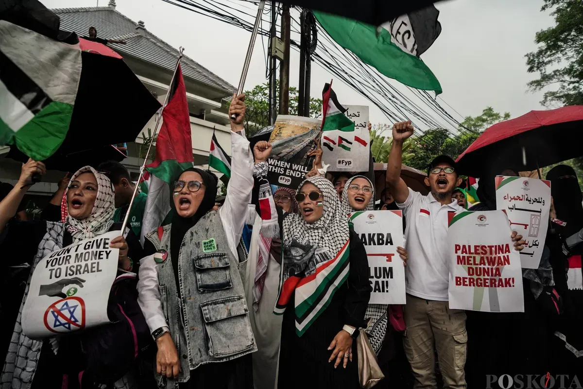 Sejumlah peserta aksi membawa poster saat mengikuti aksi bela Palestina di depan Kedutaan Besar Mesir, Jakarta, Selasa, 17 Mei 2025. (Sumber: Poskota/Bilal Nugraha Ginanjar)
