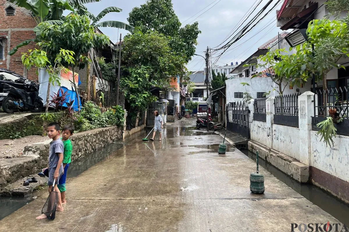 Warga Kelurahan Petogogan, Jakarta Selatan, sedang membersihkan sisa air seusai banjir, Rabu, 18 Juni 2025. (Sumber: Poskota/Pandi Ramedhan)