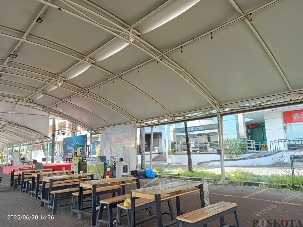 Suasana di area kuliner untuk UMKM yang berlokasi di luar sebuah pusat perbelanjaan, Grand Mall Bekasi. Deretan meja dan bangku kayu terlihat kosong, menanti kedatangan pengunjung di bawah naungan tenda. (Sumber: Poskota/Nurpini Aulia Rapika)