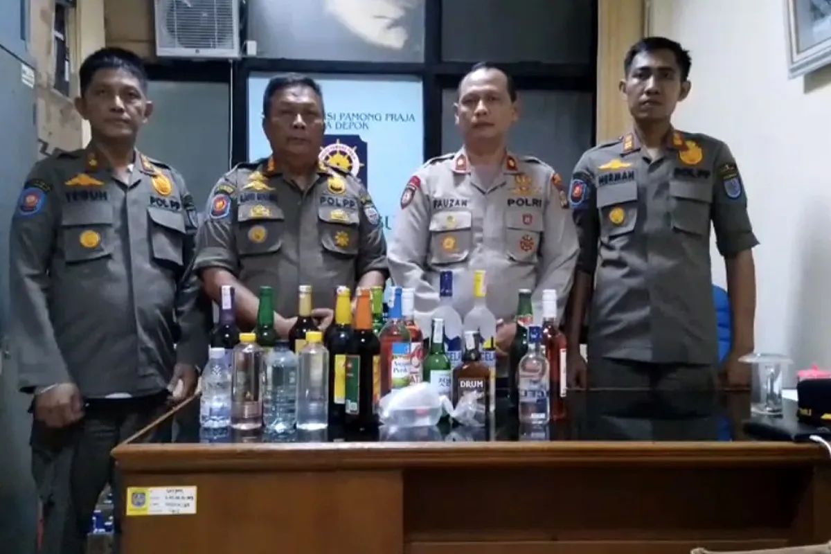 Kapolsek Bojongsari Kompol Fauzan Thohari dengan Kasi Dalops Pol PP Kota Depok Agus menyita miras operasi gabungan dari toko jamu. (Sumber: Dok Polsek Bojongsari)
