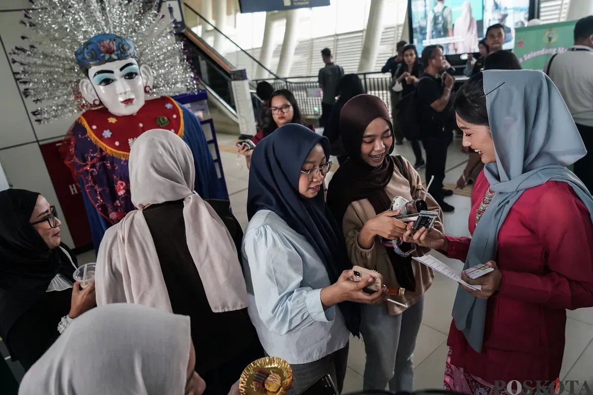Abang dan None DKI Jakarta membagikan kartu multi trip (KMT) gratis di Stasiun LRT Dukuh Atas, Jakarta, Senin, 23 Juni 2025. (Sumber: Poskota/Bilal Nugraha Ginanjar)