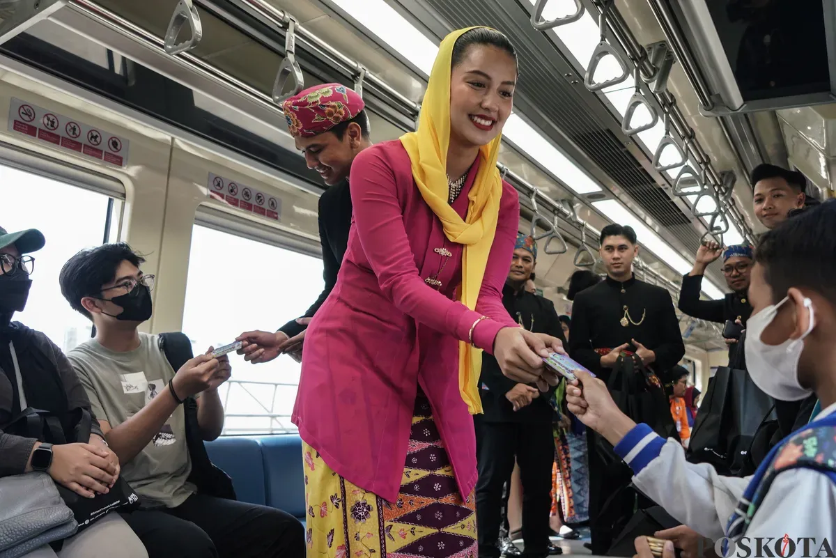 Abang dan None DKI Jakarta membagikan kartu multi trip (KMT) gratis di Stasiun LRT Dukuh Atas, Jakarta, Senin, 23 Juni 2025. (Sumber: Poskota/Bilal Nugraha Ginanjar)