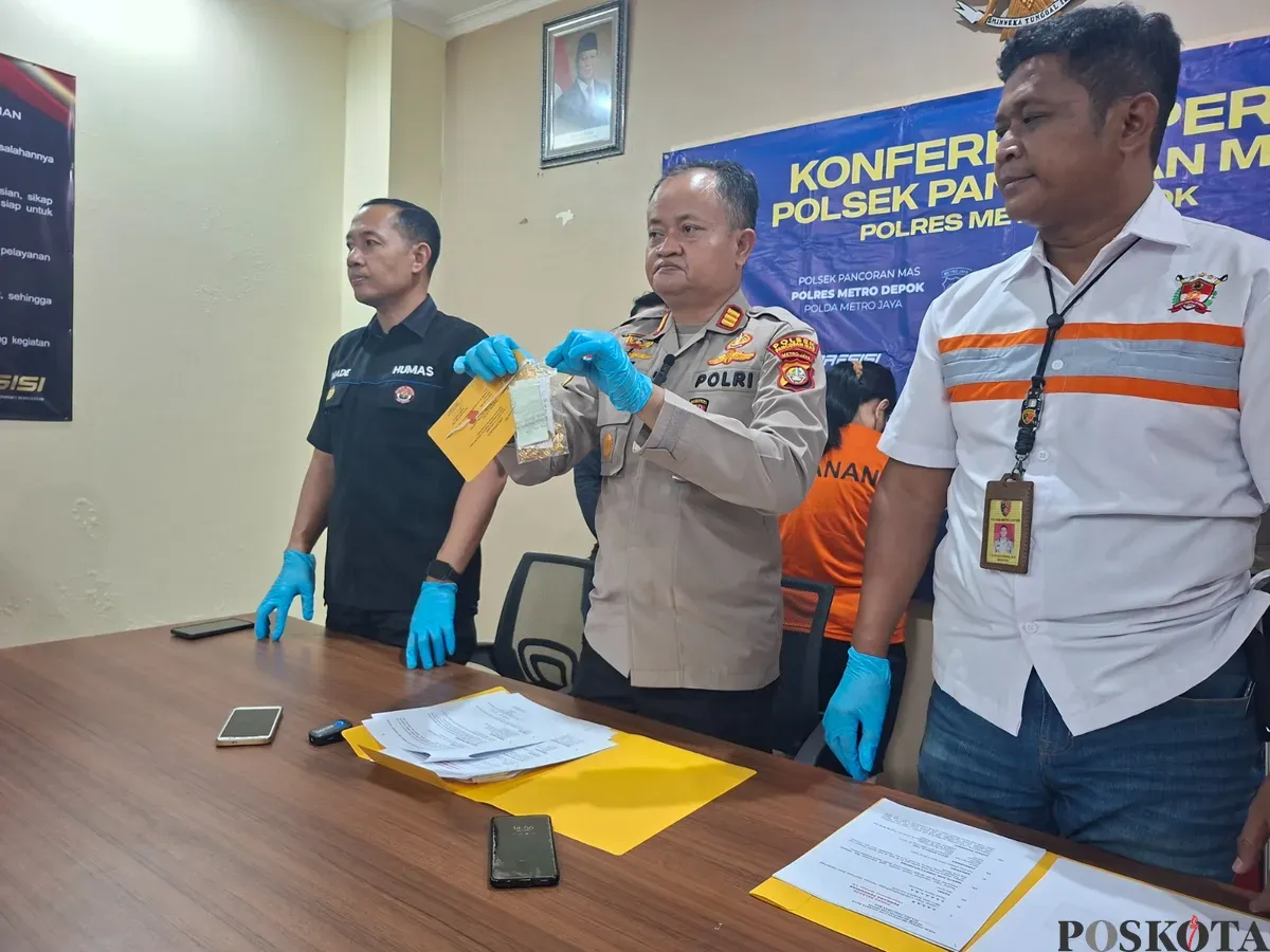Kapolsek Pancoran Mas AKP Hartono memperlihatkan barang bukti dua gelang perhiasan emas yang dicuri pelaku dari toko perhiasan tempatnya bekerja. (Sumber: Poskota/Angga Pahlevi)