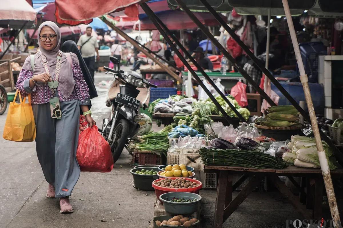 Warga berjalan membawa barang belanjaan di Pasar Kebayoran Lama, Jakarta Selatan, Senin, 23 Juni 2025. (Sumber: Poskota/Bilal Nugraha Ginanjar)