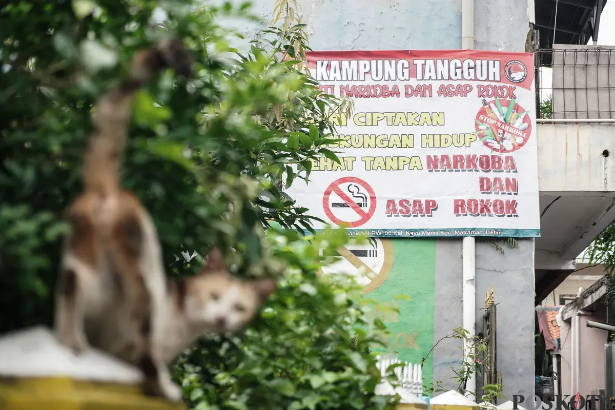 Warga berjalan melewati mural anti rokok di permukiman padat penduduk Matraman, Jakarta, 24 Juni 2025. (Sumber: Poskota/Bilal Nugraha Ginanjar)
