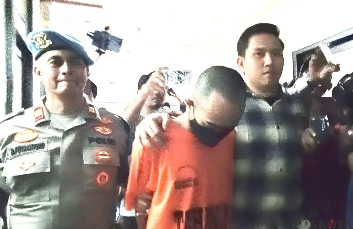 Mochamad Ichsan Ezra Candra, 23 tahun, pelaku penganiayaan ibu kandungnya sendiri di Bekasi Timur tertunduk saat digiring polisi. Ia diketahui kerap mengonsumsi obat berbahaya jenis eksimer. (Sumber: Poskota/Nurpini Aulia Rapika)