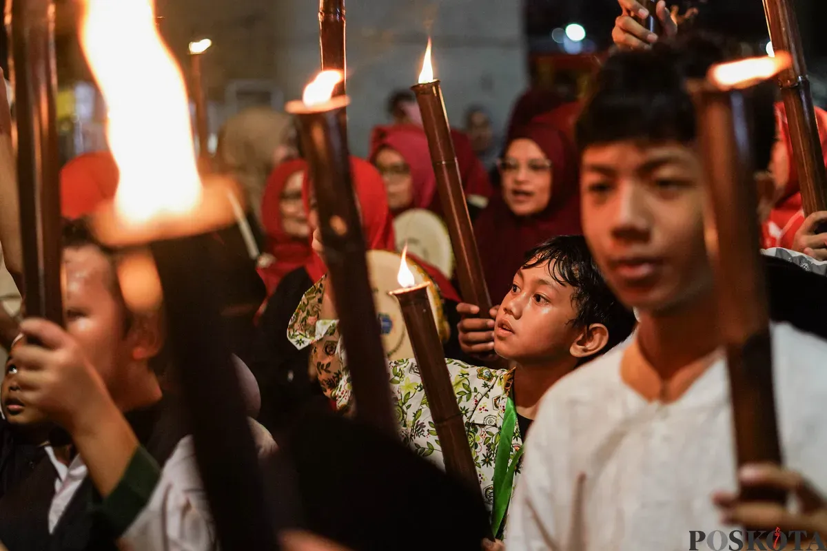 Sejumlah warga mengikuti pawai obor di kawasan Menteng, Jakarta, Kamis, 26 Juni 2025. (Sumber: Poskota/Bilal Nugraha Ginanjar)