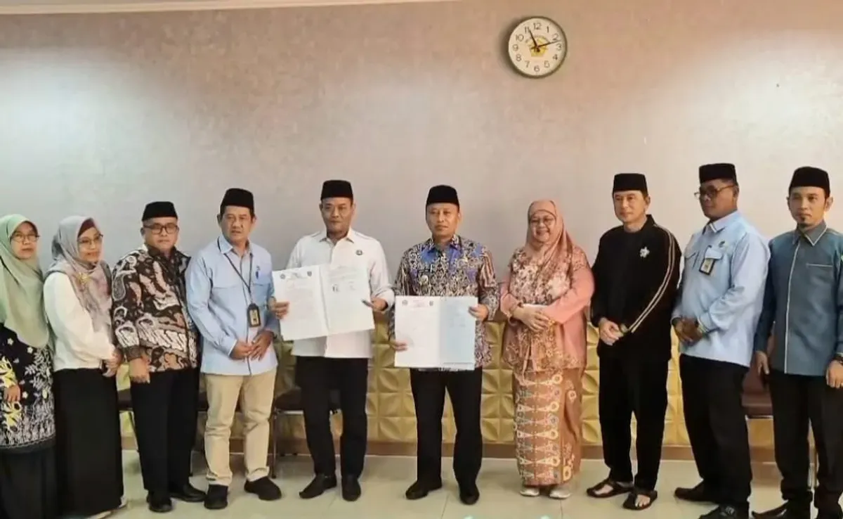 Wali Kota Depok Supian Suri bersama Kepala Kantor Kemenag Kota Depok, Enjat Mujiat, usai melakukan penandatangan kerjasama sekolah Tsanawiyah swasta gratis di Kantor Disdik Kota Depok. (Sumber: Humas Depok)