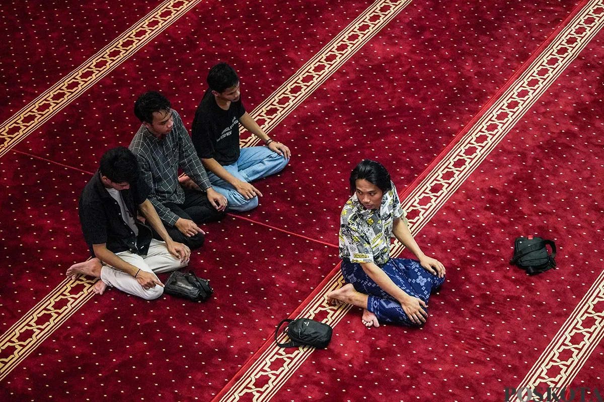 Sejumlah umat muslim membaca Alquran dan beristirahat saat menunggu datangnya kumandanga dzan Maghrib atau yang sering disebut 'Ngabuburit' di Masjid Istiqlal, Jakarta, Sabtu, 1 Maret 2025. (Sumber: Poskota/Bilal Nugraha Ginanjar)