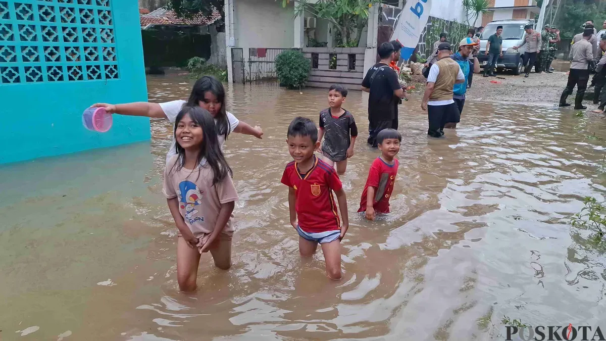 Sejumlah anak bermain di lokasi banjir pada salah satu permukiman yang terdampak banjir luapan Kali Angke, Kota Depok. (Sumber: Poskota/Angga Pahlevi)