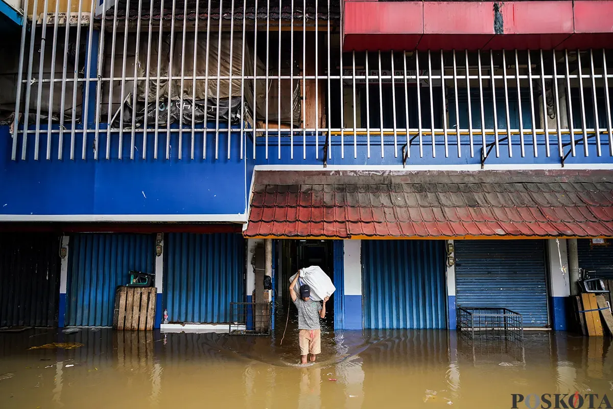 Sejumlah pedagang mengemas dan membawa barang dagangannya menggunakan karung saat bencana banjir melanda di pasar Cipulir, Jakarta Selatan, Selasa, 4 Maret 2025. (Sumber: Poskota/Bilal Nugraha Ginanjar)