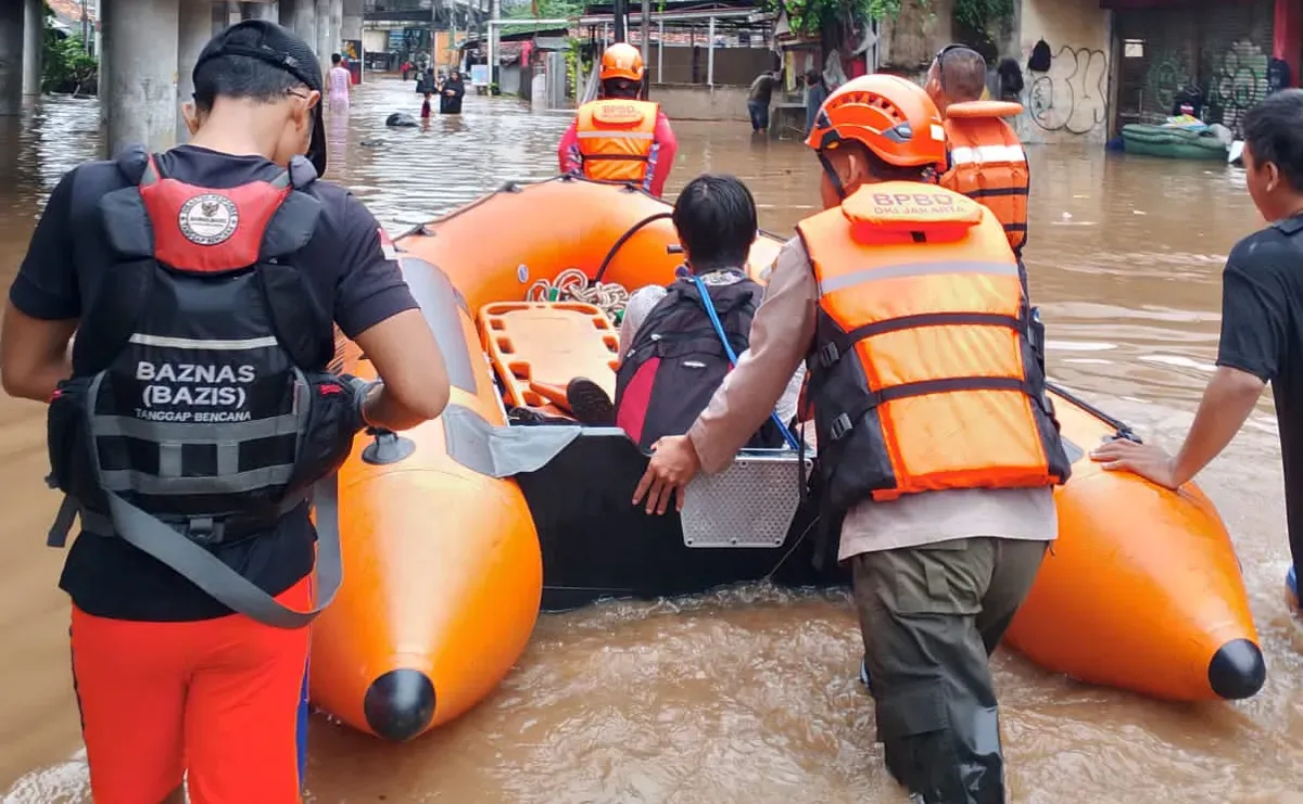 Petugas BPBD Jakarta menggunakan perahu karet untuk melakukan evakuasi warga yang terjebak banjir. (Sumber: Dok. BPBD Jakarta)