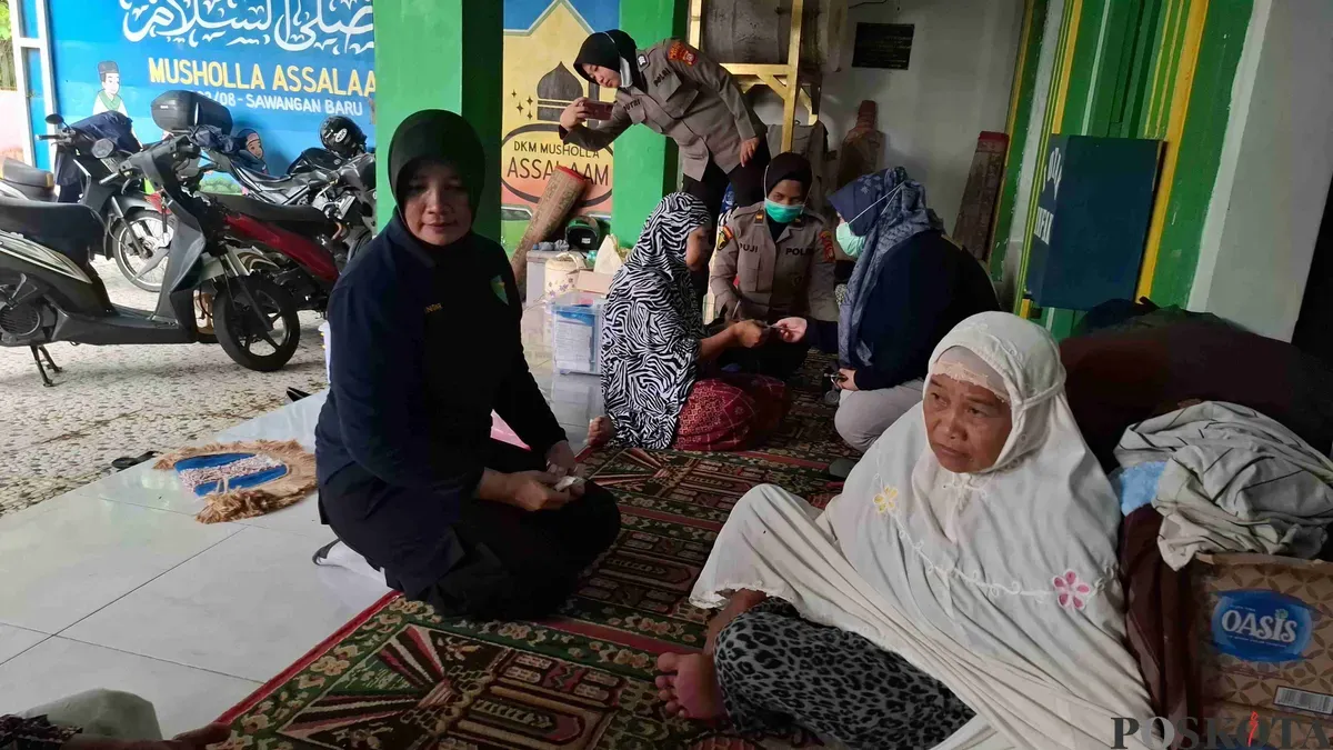 Nenek Yani saat dicek kesehatan oleh tim Dokkes Polres Metro Depok di tempat pengungsian, Musala Assalam Sawangan Baru, Kecamatan Sawangan, Kota Depok. (Sumber: Poskota/Angga Pahlevi)