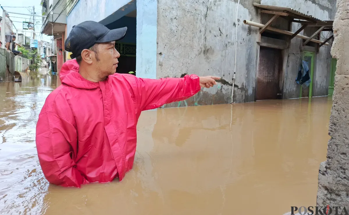 Warga menunjuk lokasi banjir di wilayah Pejaten Timur yang ketinggiannya sudah merendam rumah lantai dua, Selasa, 4 Maret 2025. (Sumber: Poskota/Ali Mansur)