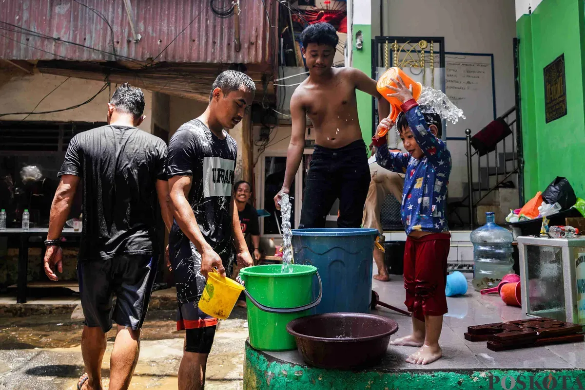 Warga membersihkan diri dan perabotan rumahnya pascabanjir di Kampung Melayu, Jatinegara, Jakarta Timur, Rabu, 5 Maret 2025. (Sumber: Poskota/Bilal Nugraha Ginanjar)