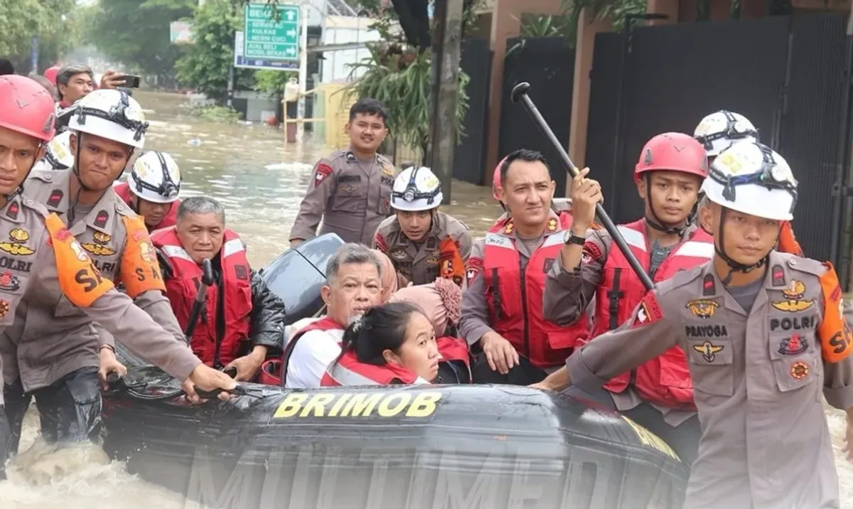 Personel Brimob melakukan evakuasi terhadap korban banjir di kawasan Bekasi. (Sumber: Dok Humas Polri)