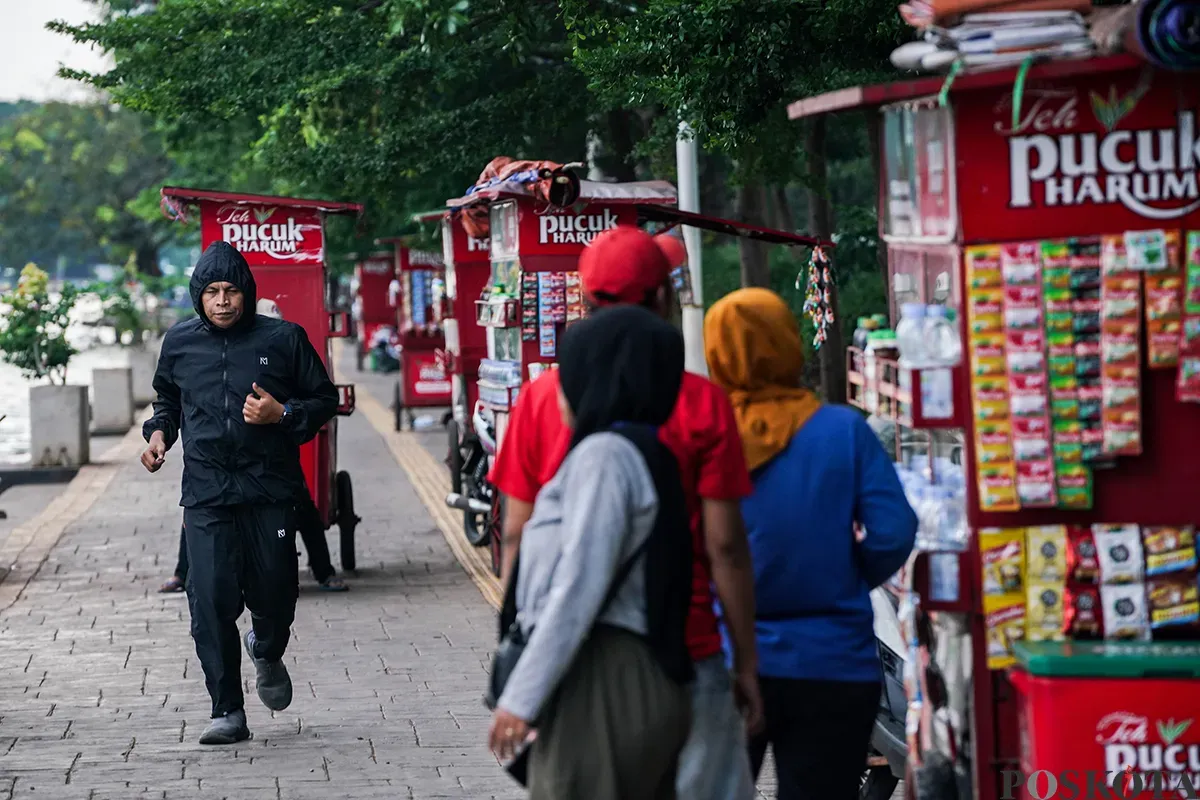 Warga mengisi waktu dengan berbagai macam aktivitas mulai dari olah raga ringan seperti lari hingga memancing ikan saat menunggu berbuka puasa di area Danau Sunter, Jakarta Utara, Kamis, 6 Maret 2025. (Sumber: Poskota/Bilal Nugraha Ginanjar)