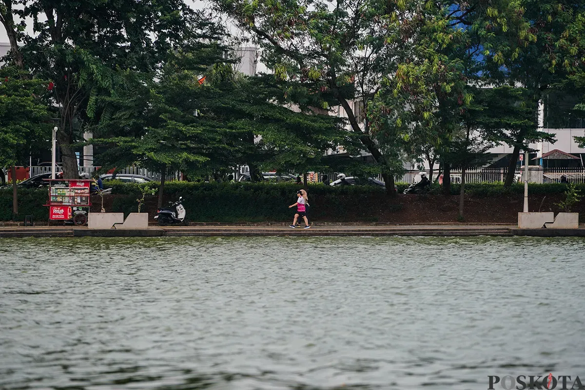 Warga mengisi waktu dengan berbagai macam aktivitas mulai dari olah raga ringan seperti lari hingga memancing ikan saat menunggu berbuka puasa di area Danau Sunter, Jakarta Utara, Kamis, 6 Maret 2025. (Sumber: Poskota/Bilal Nugraha Ginanjar)